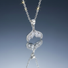 Stainless steel whale tail pendant necklace on blue grey gloss background with mirror reflection