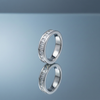 Silver-tone square-stone band ring on a blue-grey mirrored surface with reflection