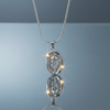 Stainless steel oval rose pendant necklace with snake chain on blue grey gloss background with mirror reflection
