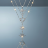 Stainless steel layered galactic necklace with star, planet and globe pendants on blue grey gloss background with mirror reflection