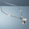 Teardrop halo pendant necklace on blue grey gloss background with mirror reflection