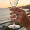 Ring on a hand holding a champagne glass