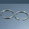 Stainless steel open hoop nose rings on blue grey gloss background with mirror reflection and sparkle flares