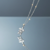 Stainless steel turtle pendant necklace on blue grey gloss background with mirror reflection