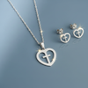 Silver Heart Cross Necklace and Earring Set with blue-grey gloss mirror background