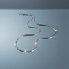 Sleek Snake Chain Necklace with blue-grey gloss mirror background